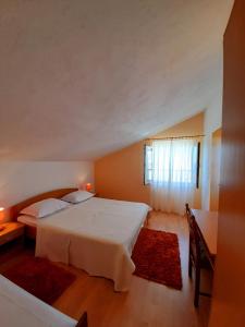 a bedroom with a large white bed and a window at Apartments and Rooms Jasna in Hvar