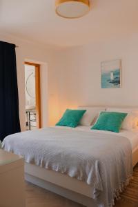 a bedroom with a large bed with green pillows at Apartment Frana in Komarna