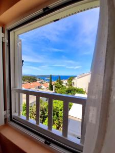 a window with a view of the ocean at Apartments and Rooms Jasna in Hvar