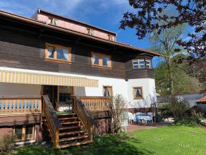 ein großes Holzhaus mit einer großen Terrasse in der Unterkunft Gästehaus Forelle am See in Schliersee