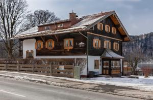 ein großes Holzhaus an der Straßenseite in der Unterkunft Gästehaus Forelle am See in Schliersee