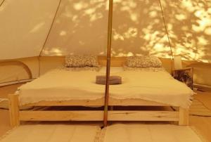 - une chambre avec un lit dans une tente dans l'établissement Glamp Natura Kryspinów, à Cholerzyn