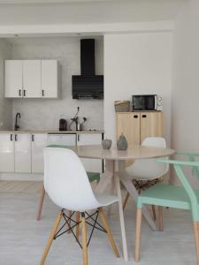 a kitchen with a wooden table and white chairs at Apartamento de diseño en la playa in Torremolinos