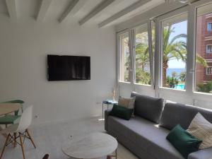 a living room with a couch and a table at Apartamento de diseño en la playa in Torremolinos