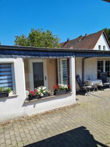 Una casa con dos ventanas con flores. en Ferienhaus Mandy en Müllrose
