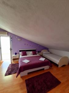 a bedroom with a large bed with purple walls at Apartments and Rooms Jasna in Hvar