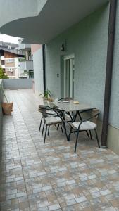a patio with a table and chairs on a tile floor at PremiumPlus Apartman in Vrnjačka Banja