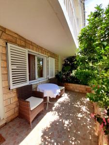 a patio with a table and chairs and a window at Apartments and Rooms Jasna in Hvar