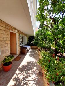 a patio with plants and trees and a building at Apartments and Rooms Jasna in Hvar