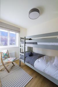 a bedroom with two bunk beds and a chair at Number 27, Swanpool in Falmouth