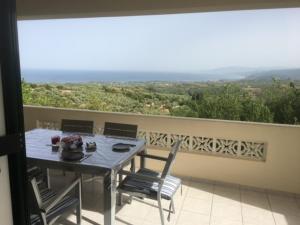 a table and chairs on a balcony with a view at Kyparissia De Wandelboom in Vrísai