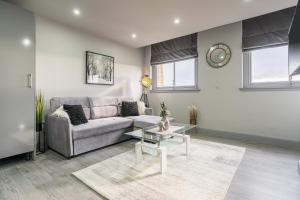 ein Wohnzimmer mit einem Sofa und einem Tisch in der Unterkunft Hotl Aparts Huddersfield Central in Huddersfield