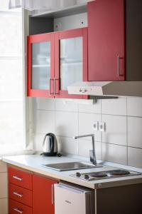 a kitchen with red cabinets and a sink at Clarinet Old Town Dubrovnik in Dubrovnik