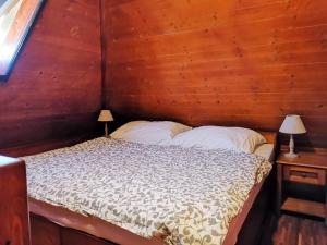 Bett in einem Holzzimmer mit zwei Lampen in der Unterkunft Senec vilka na jazere in Senec