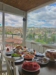 a table with plates of food on it with a view at Cappadocia Kepez hotel in Göreme