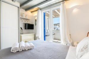 a bedroom with a bed with white towels on it at Ornos Beach House in Ornos +27 photos
