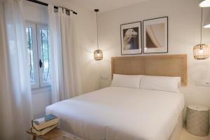 a bedroom with a white bed and two windows at Quinta la Sal in Jávea