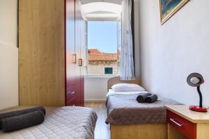 a small room with two beds and a window at Clarinet Old Town Dubrovnik in Dubrovnik
