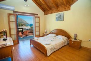 1 dormitorio con 1 cama y balcón en Fernanda's Traditional 2 floor house, en Póros