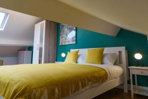 a bedroom with a large bed with a yellow bedspread at Emerald Rooms Bolton by Prime Stay in Bolton