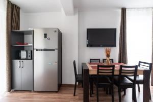 a dining room with a table and a refrigerator at Zeka's Properties in Mamaia