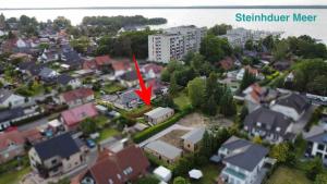 uma cidade com uma seta vermelha apontando para um edifício em Exklusives Ferienhaus Rybak mit Boxspringbetten direkt am Steinhuder Meer em Wunstorf