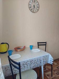 a table with two chairs and a clock on the wall at Оренда затишної 2 кімнатної квартири в самому серці Рівного in Rivne +10 photos