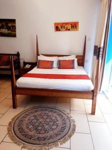 a bed sitting in a room with a window at Cowrie Shell Beach Apartments Official in Bamburi