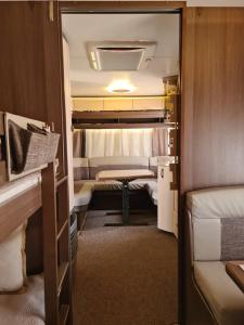 a small room with two beds and a table at Ultimate Caravan Experience - 1st Line Gradina in Sozopol