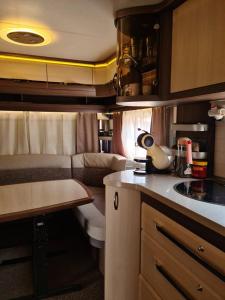 a small kitchen with a couch in a room at Ultimate Caravan Experience - 1st Line Gradina in Sozopol