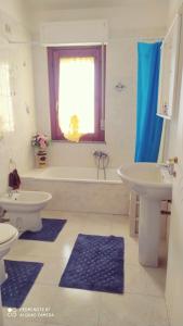 uma casa de banho com 2 lavatórios, uma banheira e um WC. em By Azzurra Tra Mare e Montagna em Sìnnai