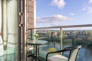 a balcony with a table and a view of a city at Luxury Riverview City Centre Apartment in Glasgow