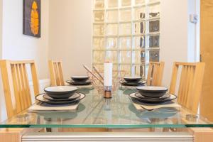 ein Esstisch aus Glas mit Stühlen und einer Kerze in der Unterkunft Luxury Riverview City Centre Apartment in Glasgow + 8 Fotos