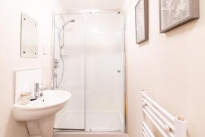 ein weißes Badezimmer mit Dusche und Waschbecken in der Unterkunft Luxury Riverview City Centre Apartment in Glasgow