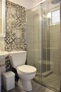 a bathroom with a toilet and a glass shower at Cabana Studios & Apartments in Kolios