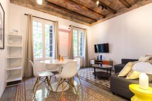 een woonkamer met een tafel en een bank bij Stay Unique Apartments Corsega in Barcelona