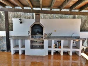 een keuken met een buitenoven in een gebouw bij Vv JARA in Caleta De Fuste