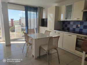 a kitchen with a table and chairs and a window at Soulac Côté Plage - Devant l'océan in Soulac-sur-Mer