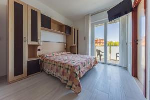 a bedroom with a bed and a large window at Residence Renadoro in Cervia