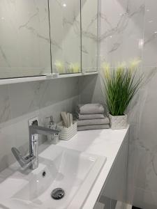 bagno bianco con lavandino e specchio di Luxury Apartment - 3 lakes a Katowice