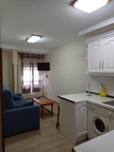 a kitchen and living room with a couch and a table at Hotel Los Robles in Cangas de Onís