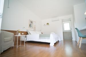 a white bedroom with a bed and a desk and a chair at B&B La Ferula in Altamura