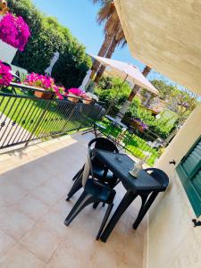 een tafel en stoelen met een parasol op een patio bij b&b I Mori in Noto Marina