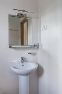 a white bathroom with a sink and a mirror at Villa Solomare in Zatoka