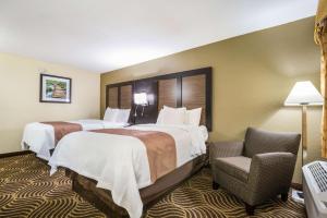 a hotel room with two beds and a chair at Quality Inn & Suites Florence - Cincinnati South in Florence +37 photos