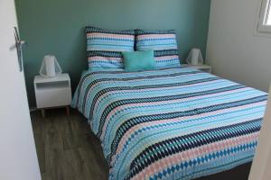 1 dormitorio con 1 cama con edredón a rayas en Pampita, en Villers-sur-Mer