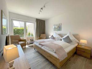 a bedroom with a large bed and a living room at Haus Nordseekrabbe in Greetsiel