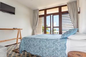 a bedroom with a bed and a large window at Dolce Vita Guest House in Lagoinha