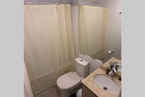 a bathroom with a toilet and a sink and a shower at Acogedor depto en barrio residencial, La Serena in La Serena