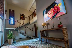 uma sala de estar com escadas e um quadro na parede em Dolce Vita Guest House em Lagoinha